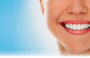 A woman is smiling while being at the dentist